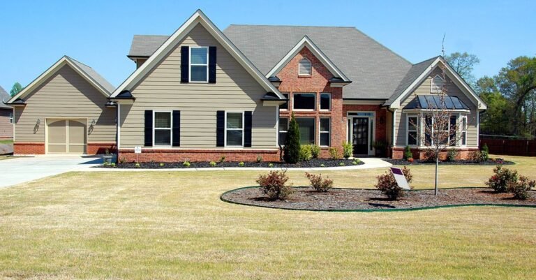 A suburban house showing its shingle roof, siding and concrete driveway in one frame, the three surfaces that need different cleaning methods