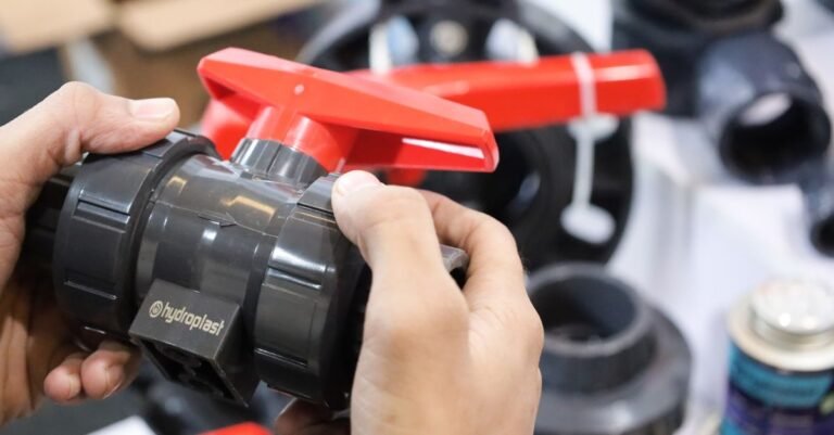 Two hands inspecting the body of an industrial valve at close range, the same check that starts any unloader repair