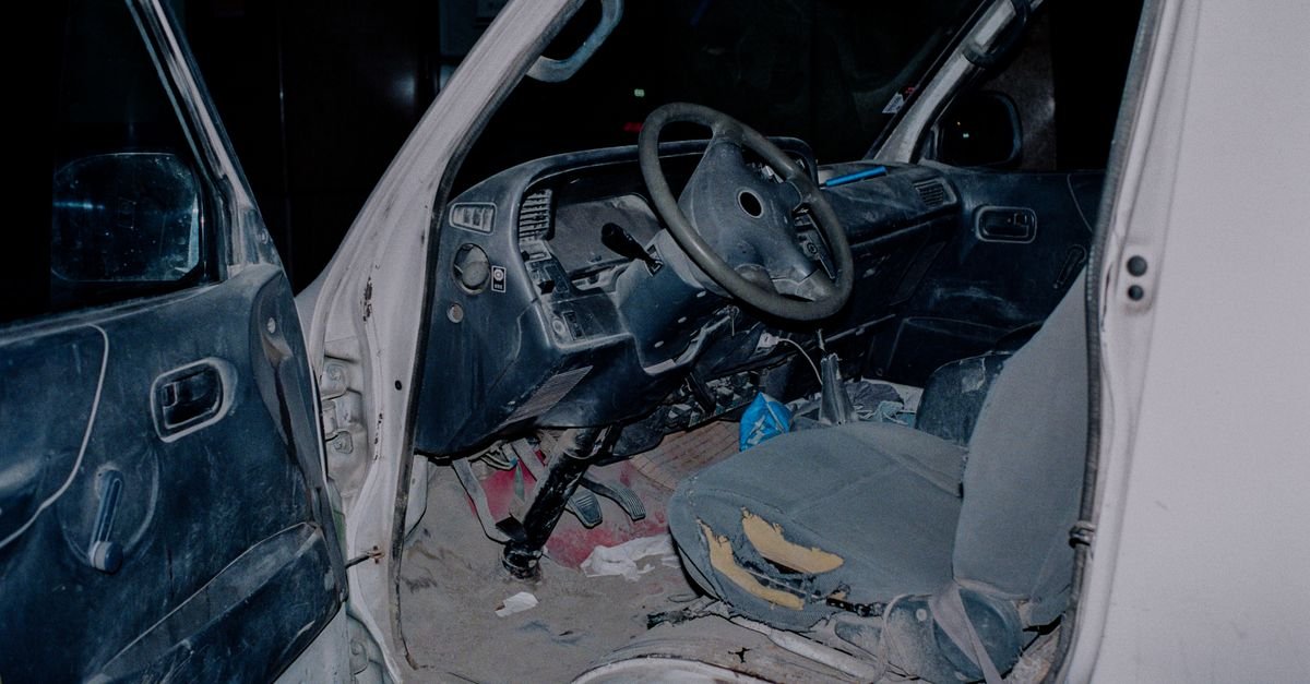 Worn interior of an old work truck with an unlined, dirty floor