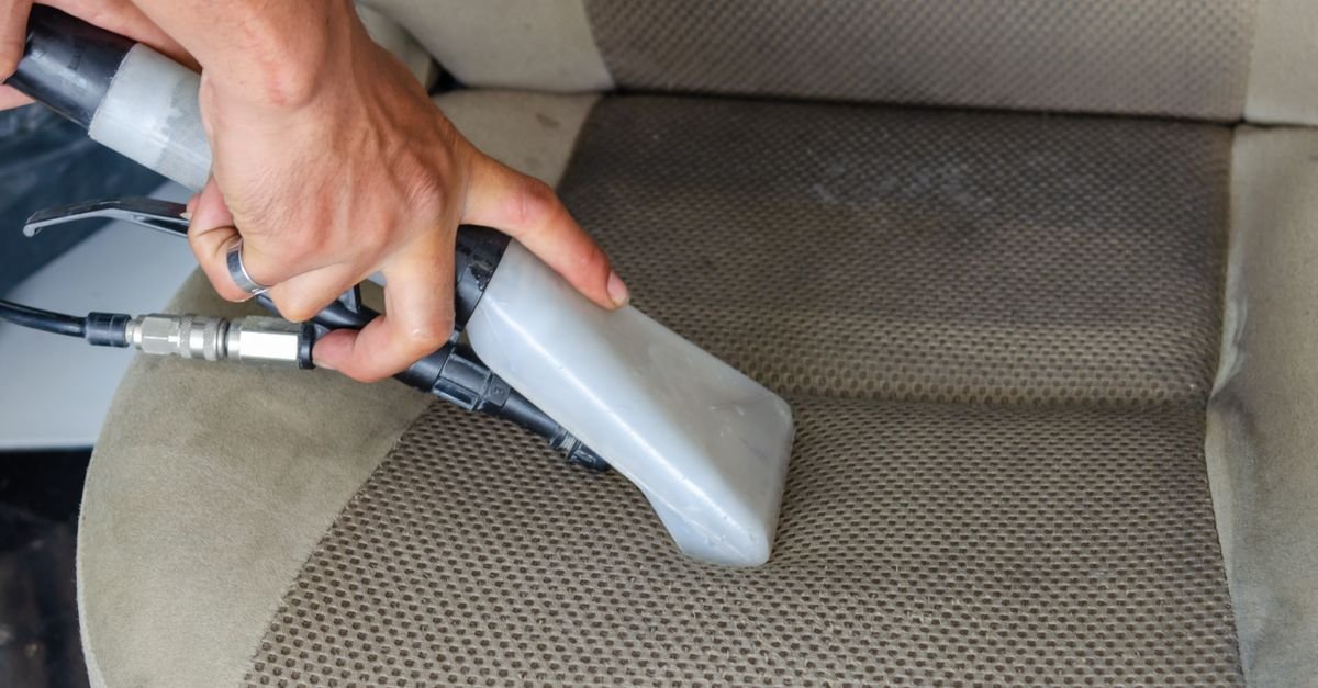Vacuum nozzle being used to deep clean a fabric car seat