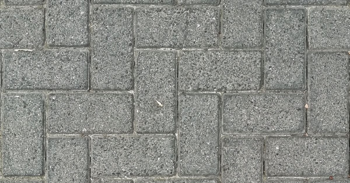 Grey stone pavers laid in a herringbone pattern photographed from directly above