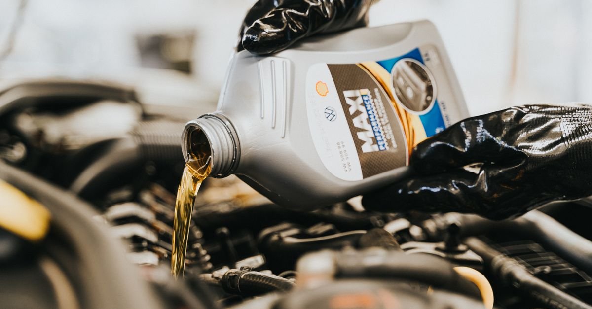 A mechanic pouring fresh engine oil during routine maintenance