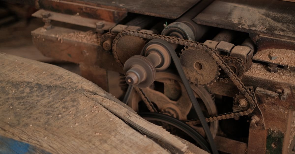 A workshop machine driven by stepped cone pulleys with a belt running between them, the classic arrangement for turning one shaft at a different speed from another