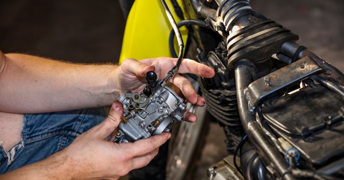 Close-up of a mechanic's hands working on a carburetor