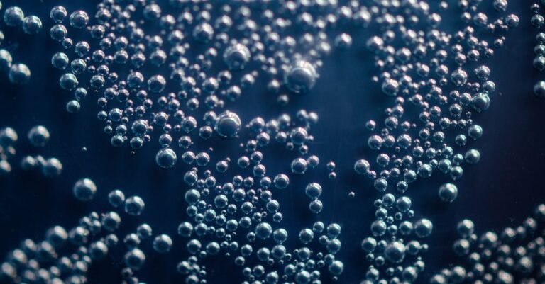Macro photograph of vapour bubbles suspended in water, the same cavities that form and collapse inside a starved pressure washer pump