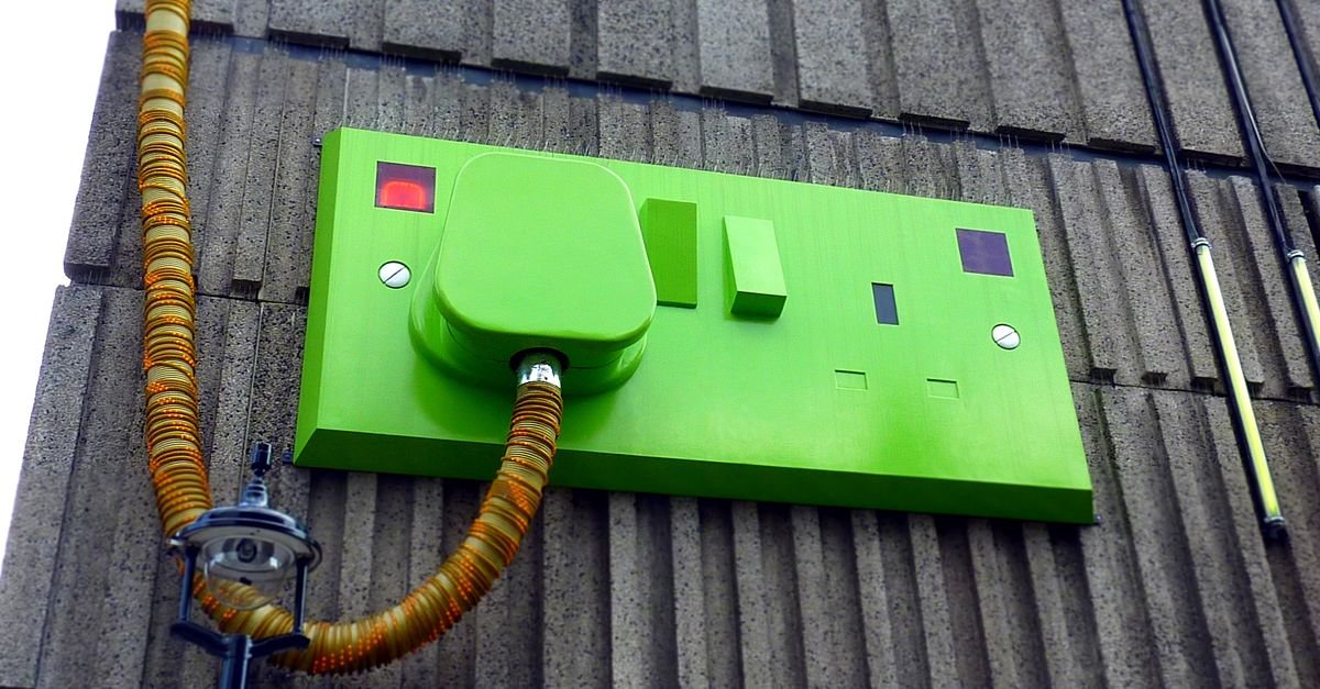 An outdoor mains outlet mounted low on an exterior building wall, the start of the power path for any pressure washer
