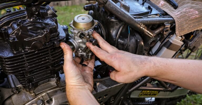 Hands working on a small engine carburetor outdoors while tracing a fuel leak