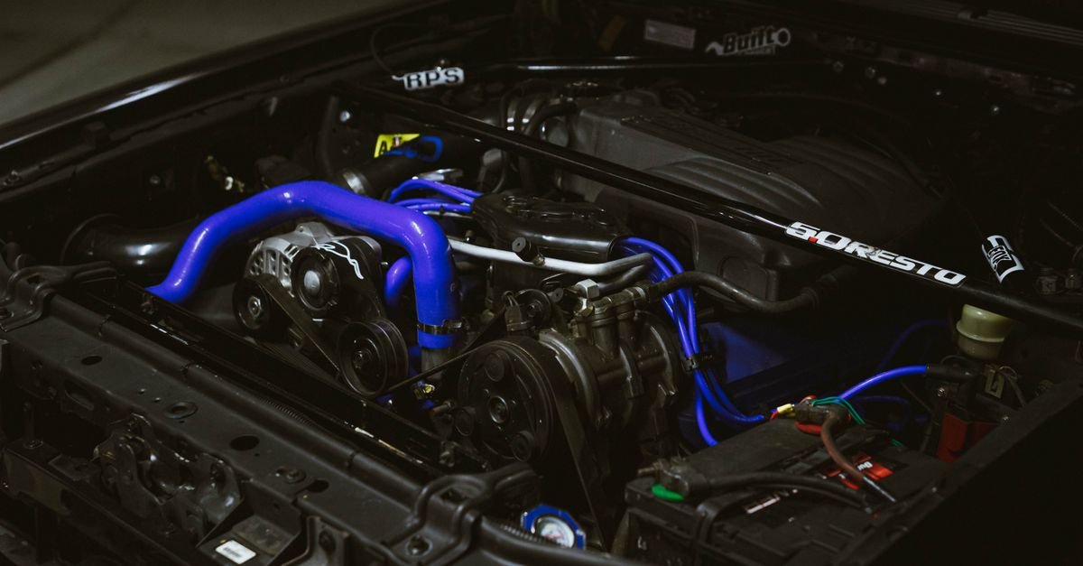 Flexible rubber hoses routed across an engine, the kind of line that hardens and cracks with age