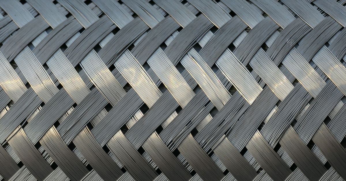 Woven steel wire mesh with interlaced strands, the same braided reinforcement that carries the pressure inside a washer hose