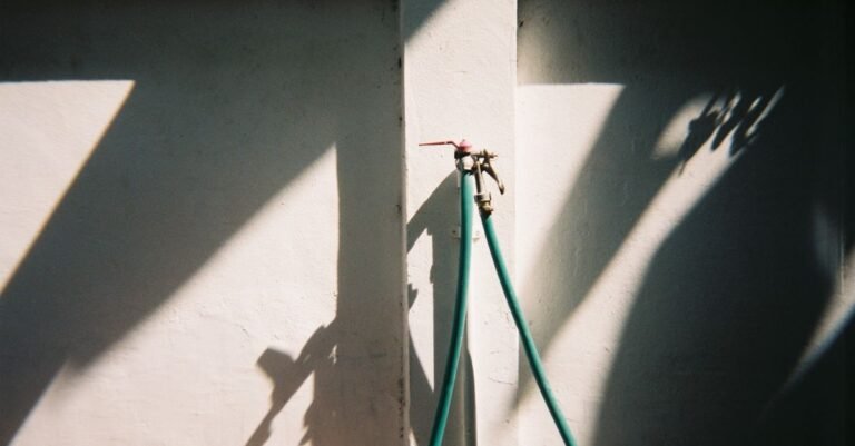 Outdoor water spigot with a garden hose attached supplying a pressure washer
