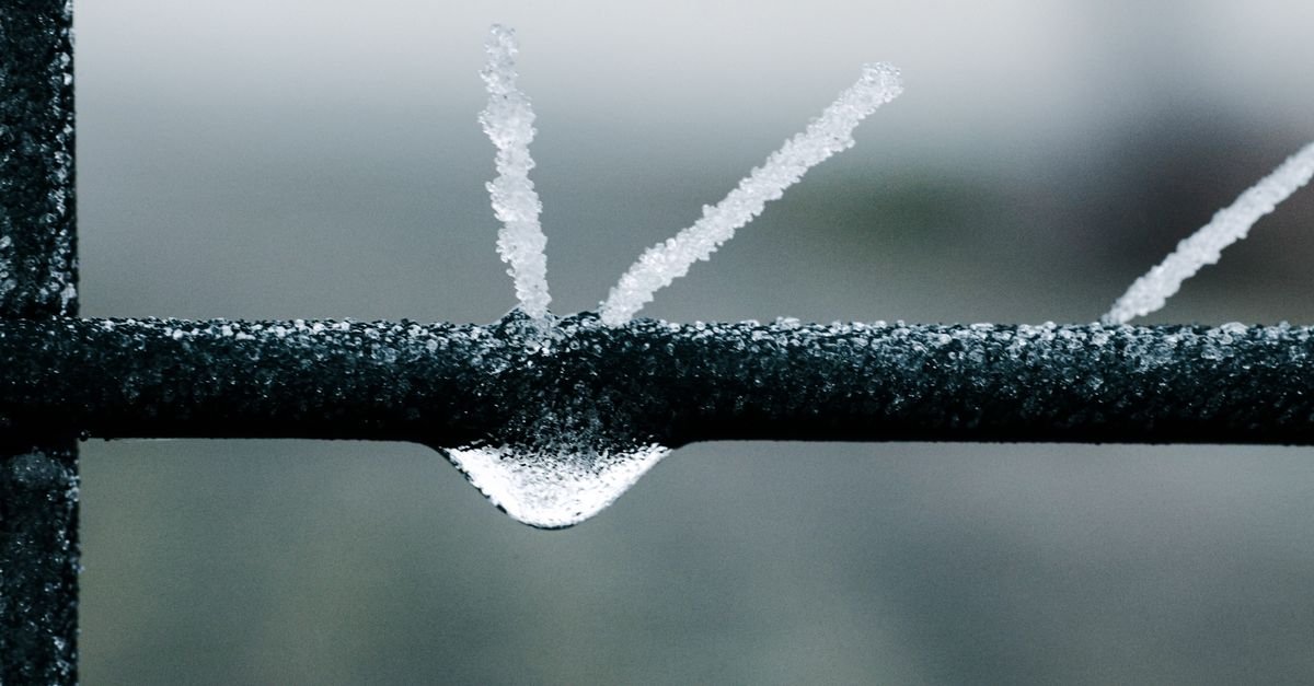 Ice crystals forming across a metal surface in freezing conditions