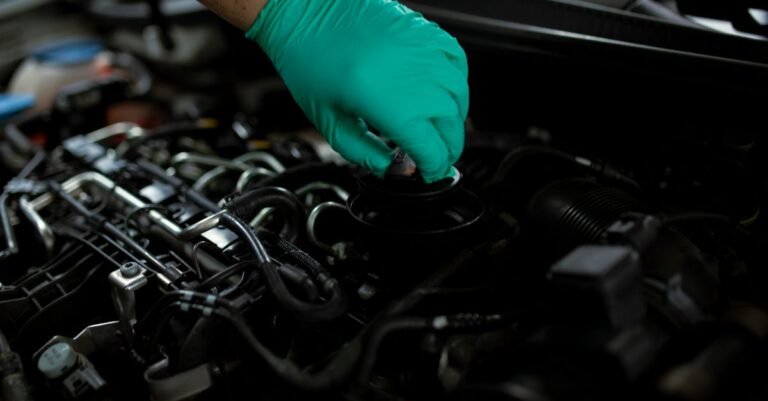 Gloved hands changing engine oil during routine small-engine servicing
