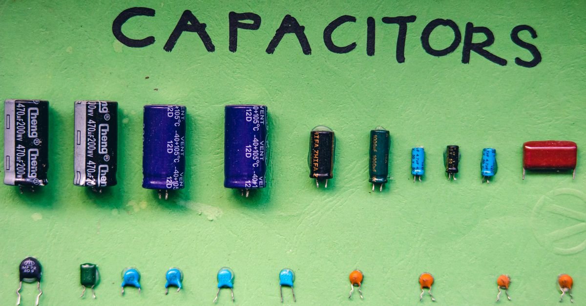 A tray of assorted electrolytic capacitors, the component that gives a single-phase motor its starting torque