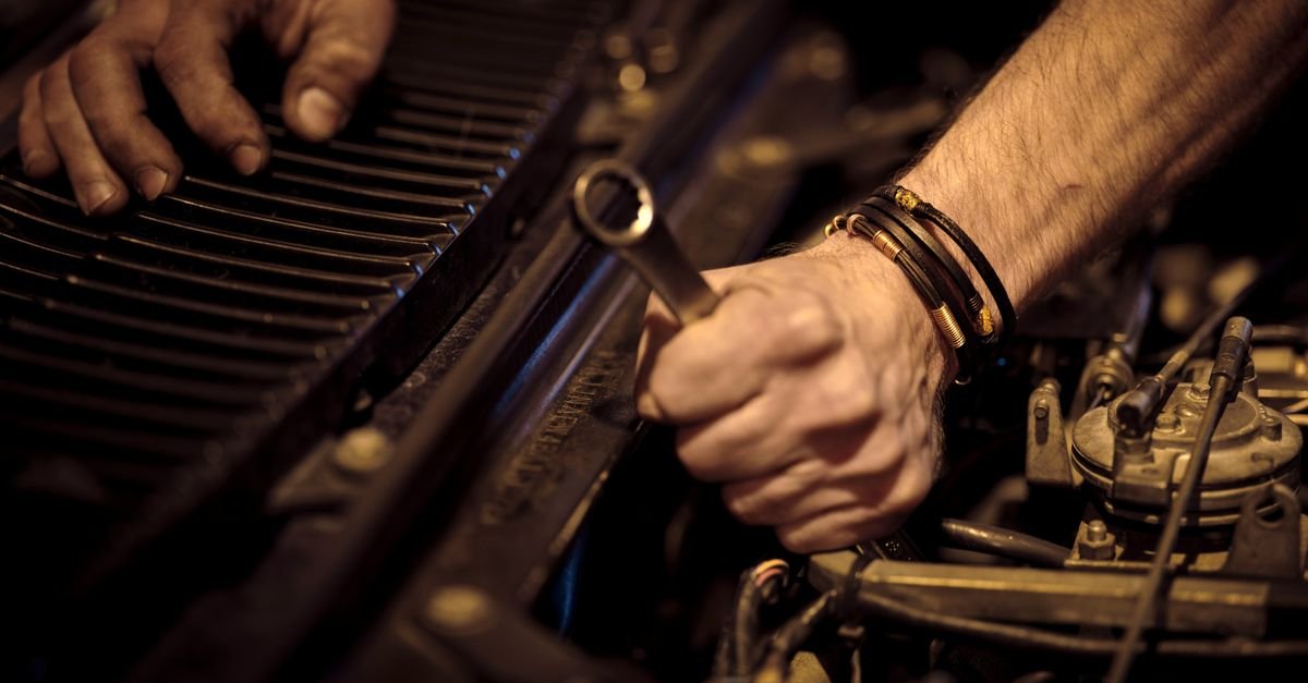 A mechanic's hands working on an engine with a wrench, the half of the machine that determines whether a pump ever reaches its rated output