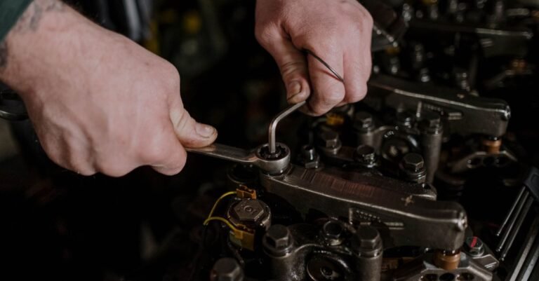 A mechanic using a wrench and an Allen key to work on an engine, the two tools needed to seat a replacement pump on its shaft