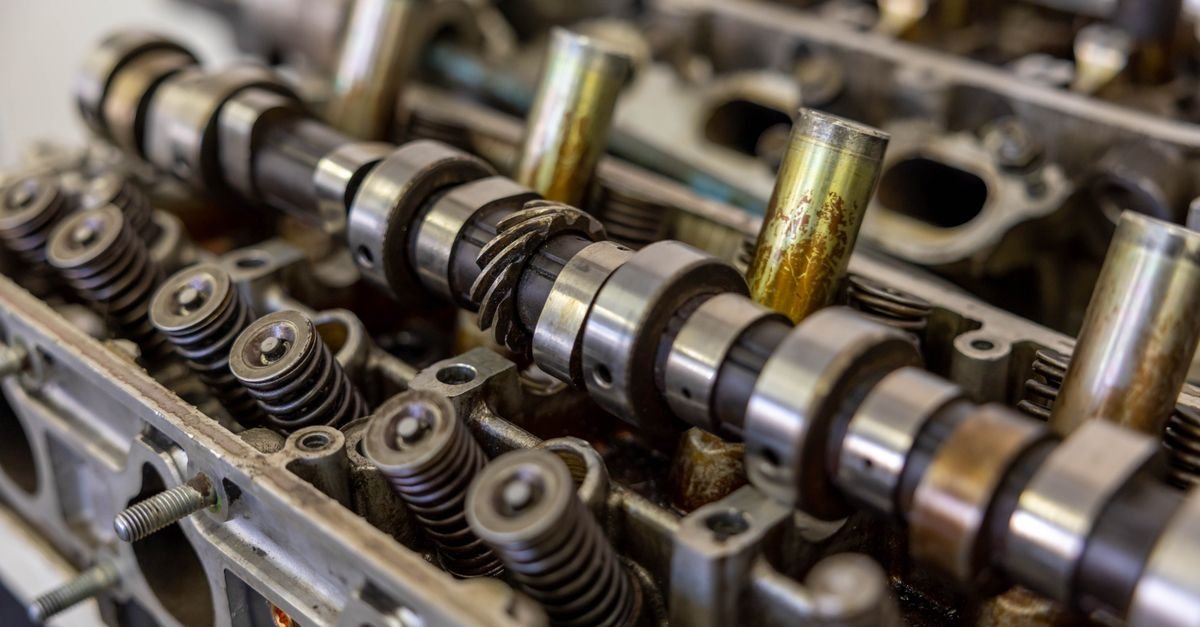 A camshaft running in its bearings inside an engine block, the same kind of rotating assembly in a pressure washer crankcase that knocks once a revolution when a bearing goes slack