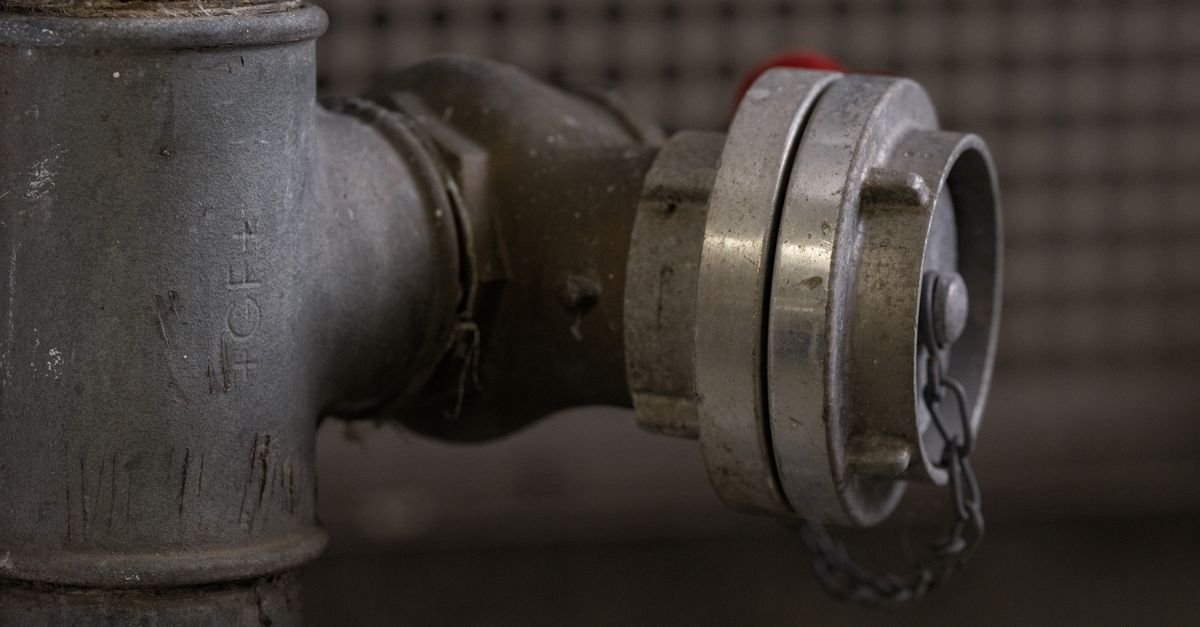 Close-up of a corroded metal fitting with a chain, showing the surface damage that ends a coupler's service life