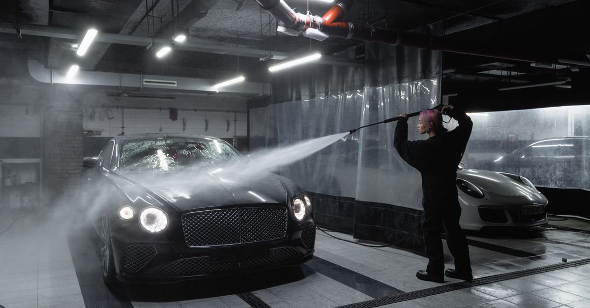 Person handling a pressure washer wand in a dim garage, where a partly seated nozzle collar is easy to miss
