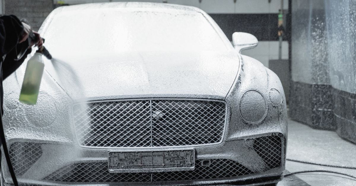 A car covered in a thick layer of detergent foam before rinsing