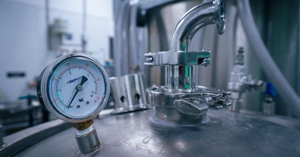 A pressure gauge mounted on a stainless steel vessel, the kind of dial instrument whose accuracy grade is printed and rarely read