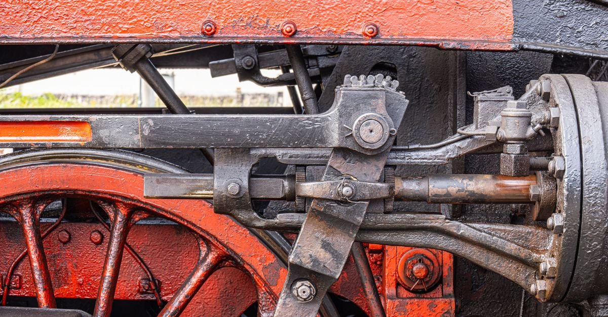 A locomotive piston and connecting rod on a driving wheel, the same crank-driven reciprocating stroke a pump plunger makes