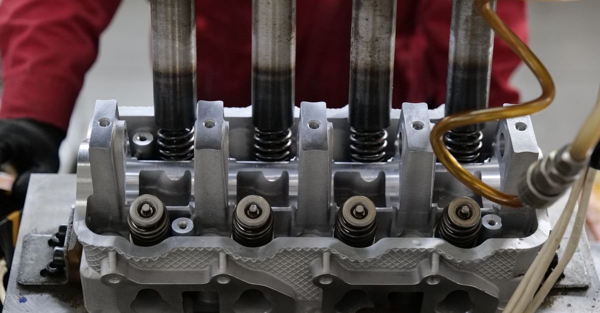 A metal cylinder head with valve springs and seats exposed, the kind of sealing faces that let a plunger stroke go to waste when they wear