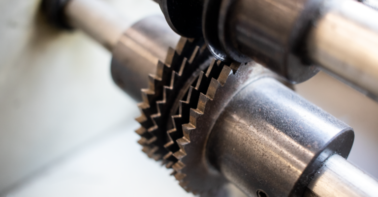 Interlocking machined metal gears meshed together inside a machine, the job every drive connection does between two shafts