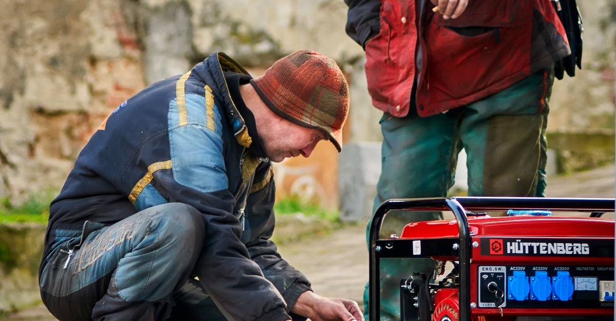 Two technicians working on a red engine-driven power unit outdoors
