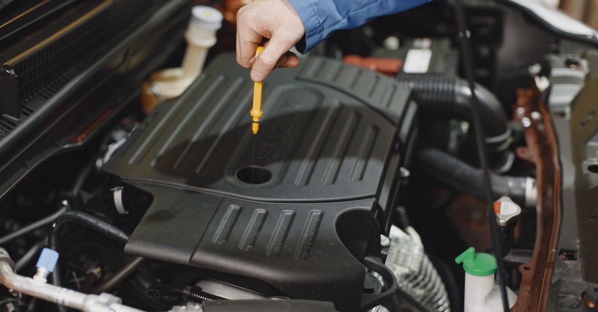 A person checking an oil level with a dipstick