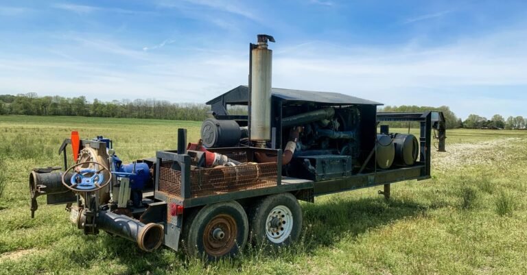 Engine-driven water pump bolted directly to its motor in an open field, the same direct-drive layout pressure washers use