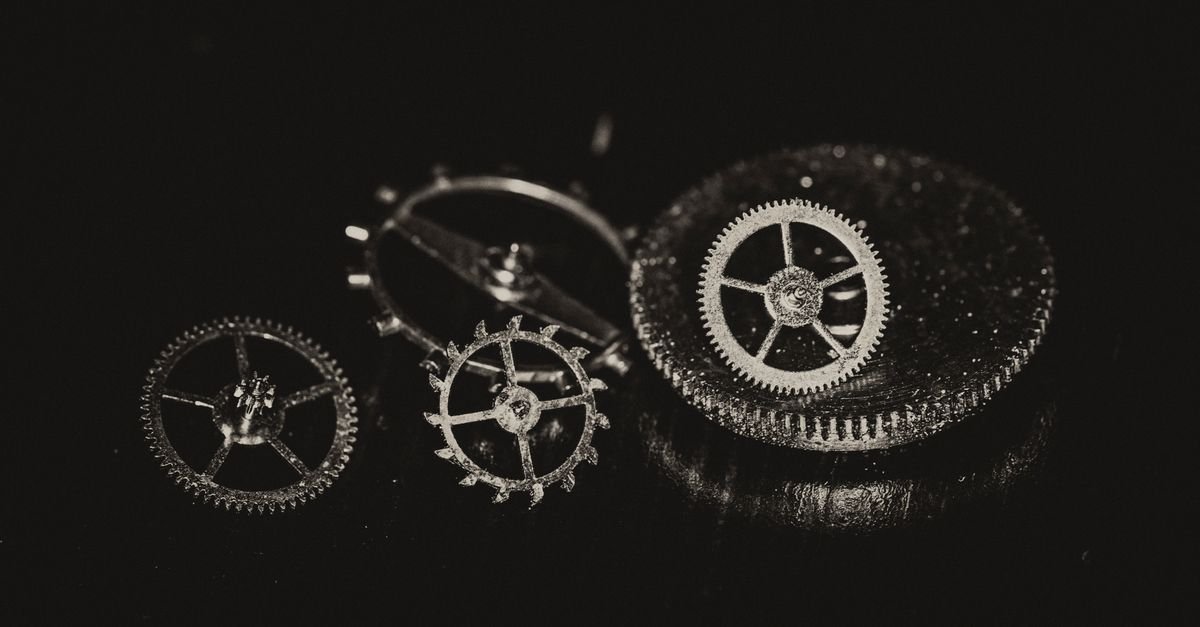 Interlocking metal gears and mechanical linkages inside a dark machine housing, the kind of mechanical feedback arrangement a small-engine governor uses