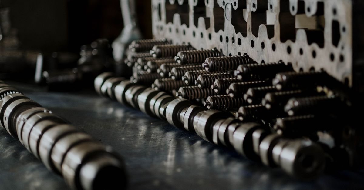 Detailed close-up of engine top-end components, camshafts and valve springs laid out on a workbench