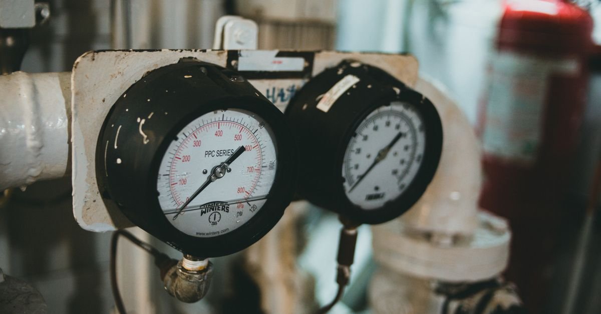 Industrial pressure gauges mounted on machinery, the kind of reading a total stop switch acts on