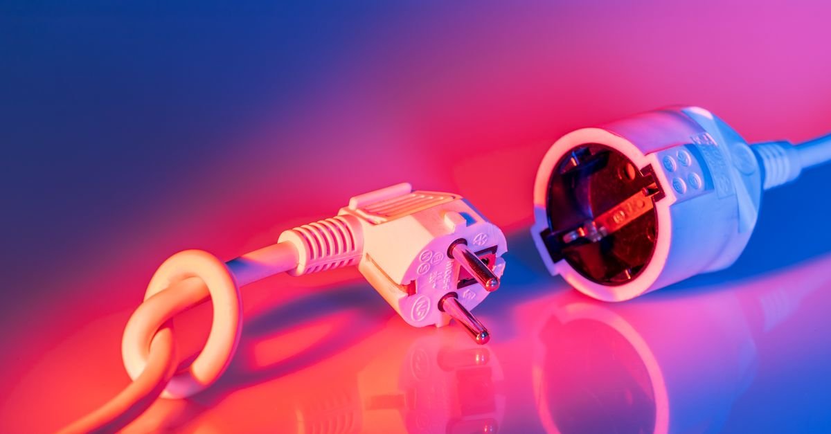 Close-up of a mains plug seated in a socket, the connection most likely to be sitting in water outdoors