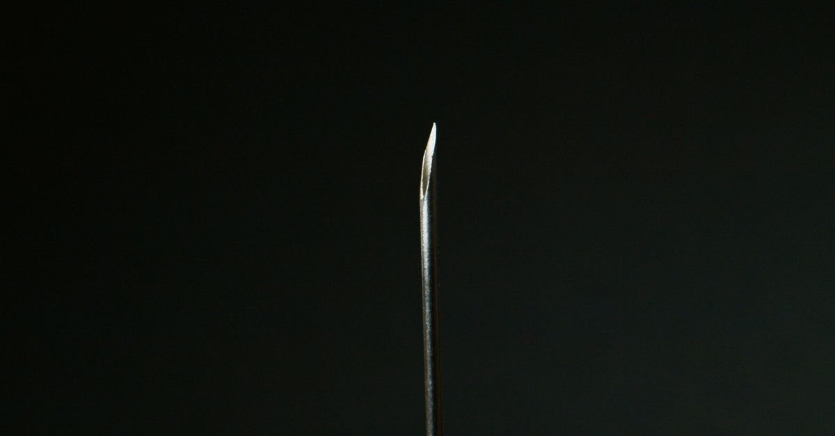 Macro view of a sharp steel needle, exactly the kind of tool that permanently ruins a calibrated nozzle orifice