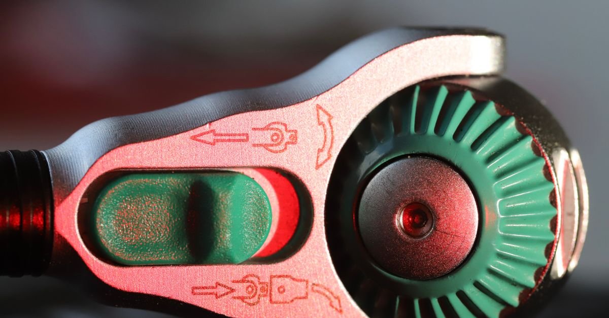 A close-up of a mechanical gauge knob with indicator markings around its collar
