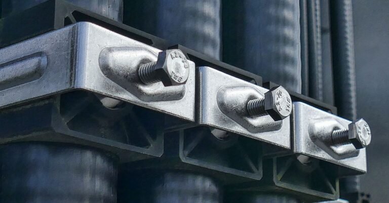 Macro view of metal bolts clamping two machined faces of industrial machinery together, the joint that holds a pressure washer's engine, pump and frame in line