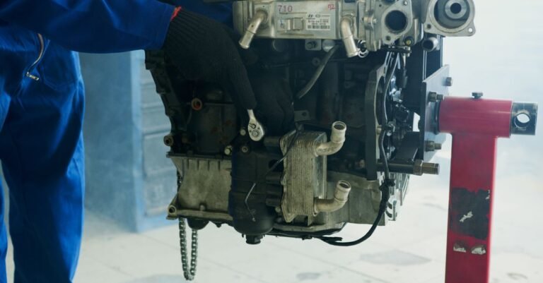 Gloved mechanic using a wrench on an engine fastener in a workshop