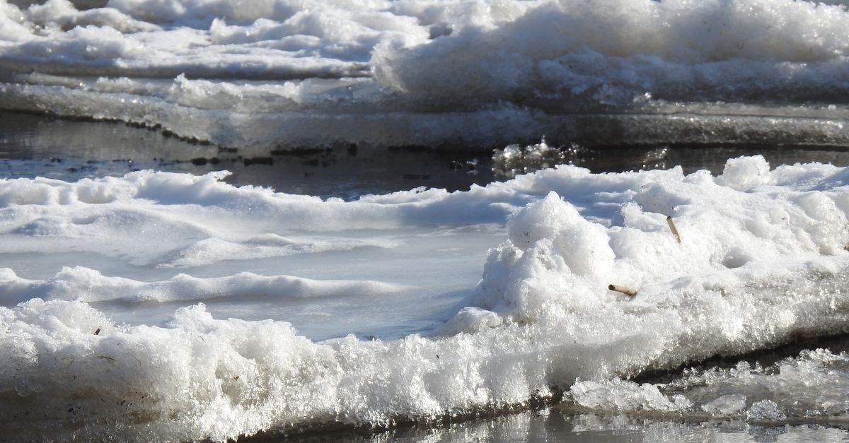 Ice formations spread across a frozen lake surface in low winter sunlight, the expansion that splits a sealed pump head