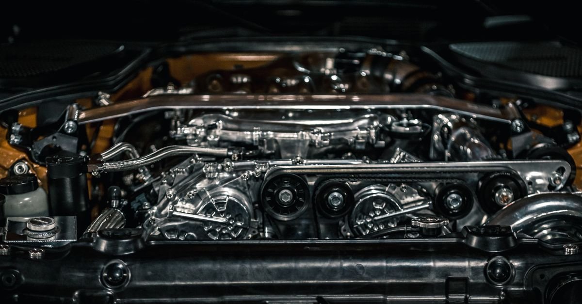 Overhead view of a clean engine bay under an open hood after washing, with polished metal components and dry surfaces