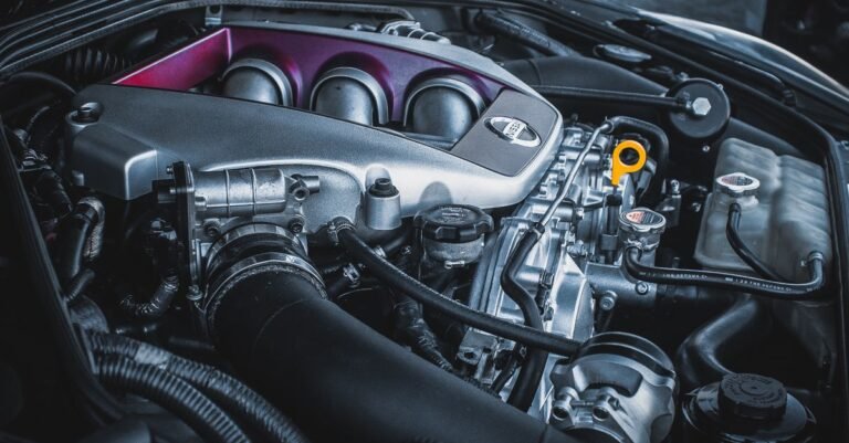 Open car hood showing a modern four-cylinder engine bay with intake ducting, wiring and fluid reservoirs