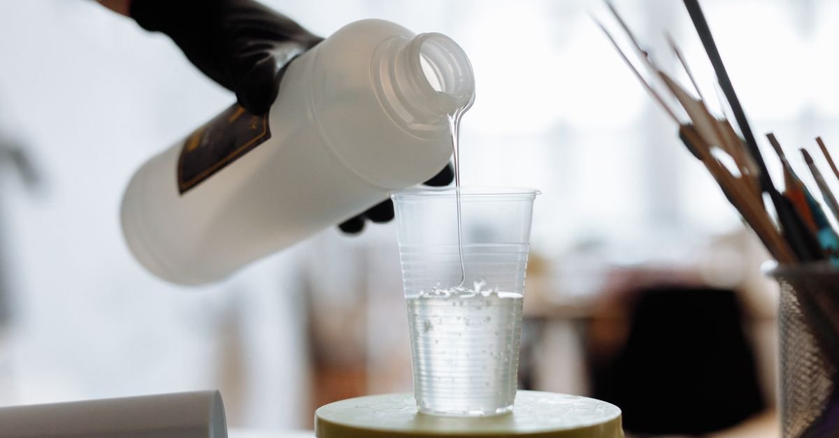 Liquid cleaning concentrate being poured from a bottle into a clear measuring cup