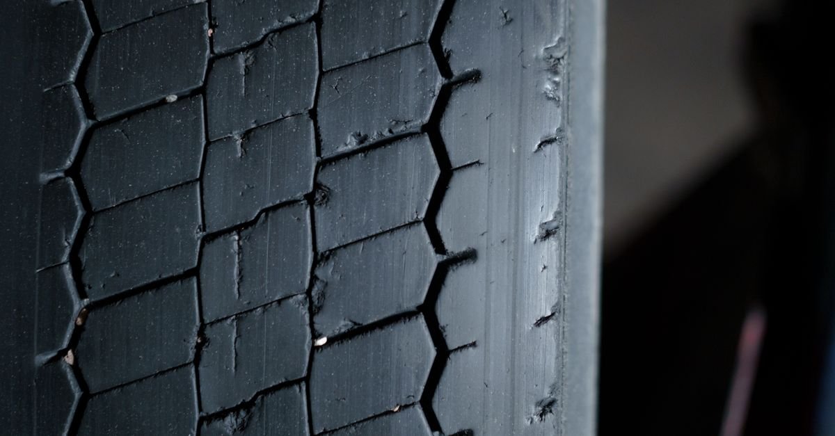 Close-up of a worn car tire tread showing the grooves and rubber compound in detail