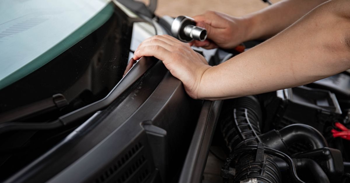 Hands turning a socket wrench on a small engine during a home repair