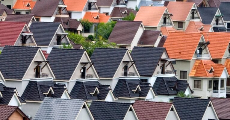 Rows of suburban house roofs seen from above, the kind of asphalt shingle surface soft washing is designed for