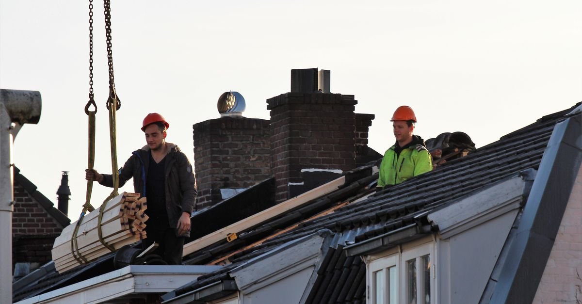 Workers on a residential rooftop, the reach and fall protection a professional soft wash crew brings to the job