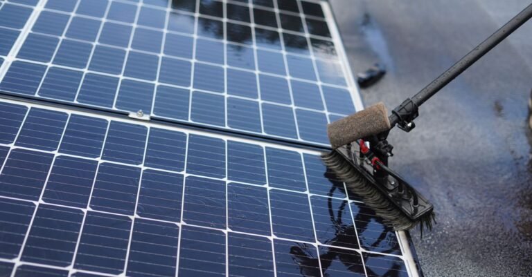 Close-up of a soft brush head being drawn across the glass of a solar panel during cleaning