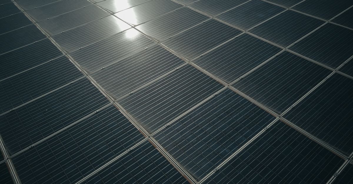 Sunlight reflecting off the surface of angled solar panels, the air-to-glass boundary that the anti-reflective coating is there to manage