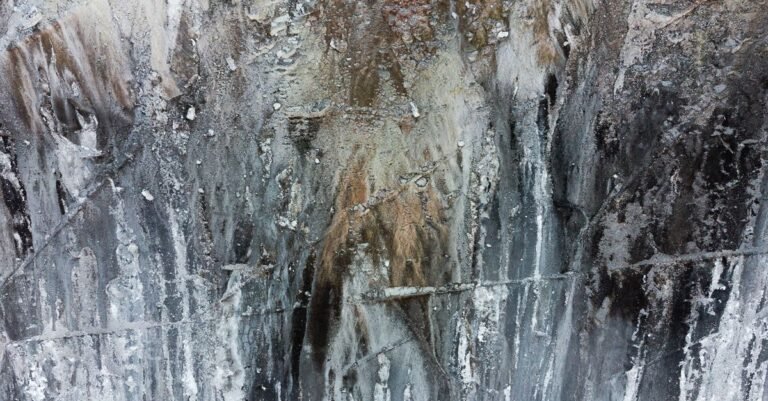 Close-up of pale crusted mineral deposits built up in layers where mineral-rich water has evaporated