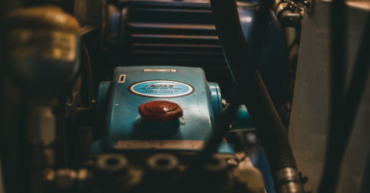 Close-up of a blue industrial engine with mechanical parts and hoses